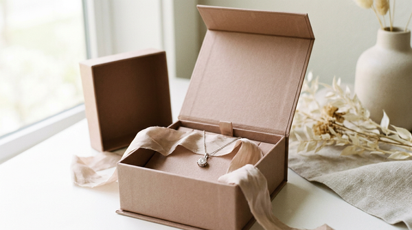 A delicate lab-grown diamond pendant necklace in an open gift box with soft ribbon