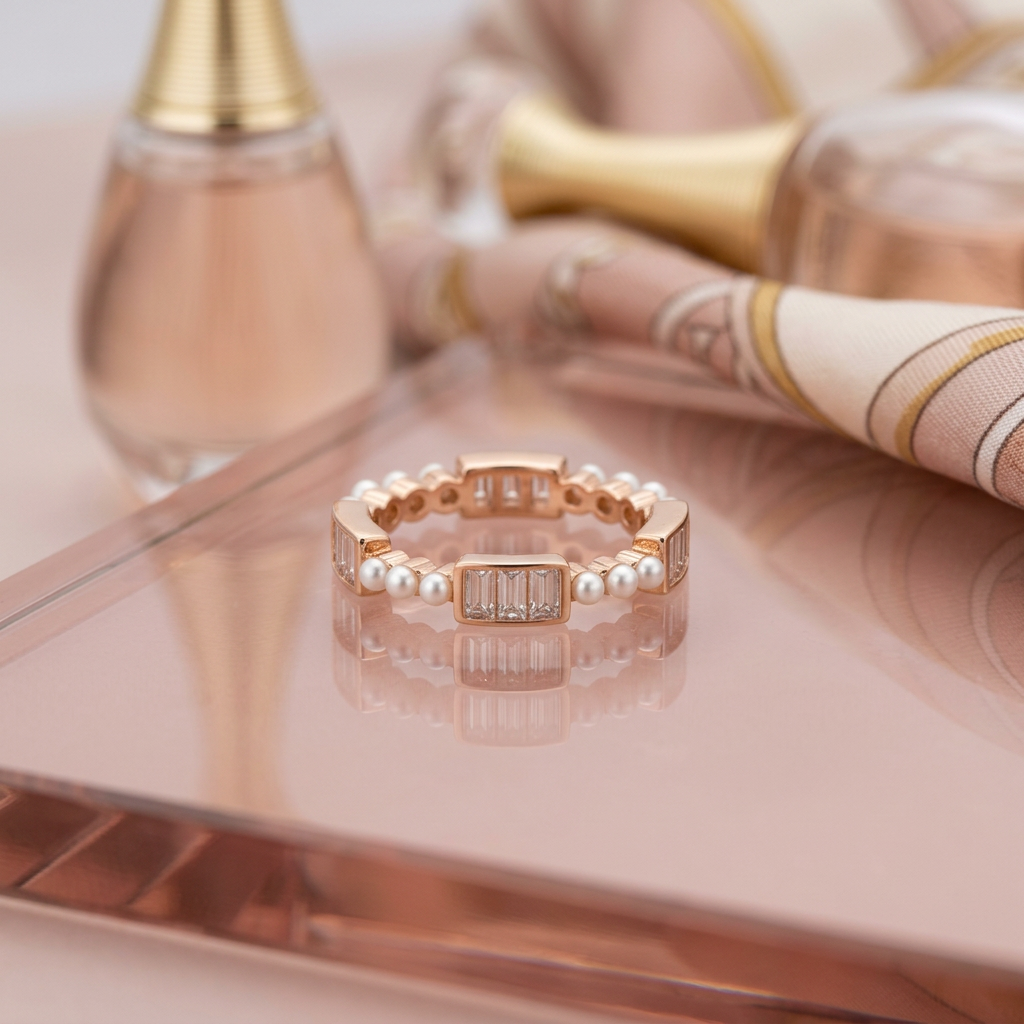 Side profile of a rose gold ring displaying a repeating rhythm of rectangular cut stones and fine seed pearls.