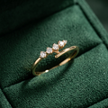 Fluid rose gold open ring featuring a high-polish bypass silhouette accented by four graduated round diamonds.