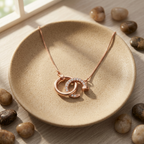 An architectural open pendant in rose gold with fine pavé details, suspended elegantly from a classic box chain.