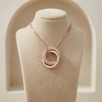 Interlocking rose gold bands in a sharp architectural silhouette, contrasting polished surfaces with crystal pavé.