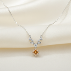 Sculptural baguette accents framing a honeyed lozenge-cut gemstone on a refined polished silver necklace for women.