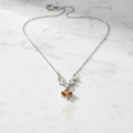 Sculptural baguette accents framing a honeyed lozenge-cut center stone pendant on a polished silver chain.