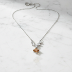 Sculptural baguette accents framing a honeyed lozenge-cut center stone pendant on a polished silver chain.