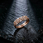Macro view of a tiered rose gold band showing alternating marquise and round stones set in a precise crown pattern.