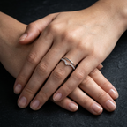 Macro photo focusing on the intricate micropavé stones set into a high-polish silver chevron V-shaped wedding band.