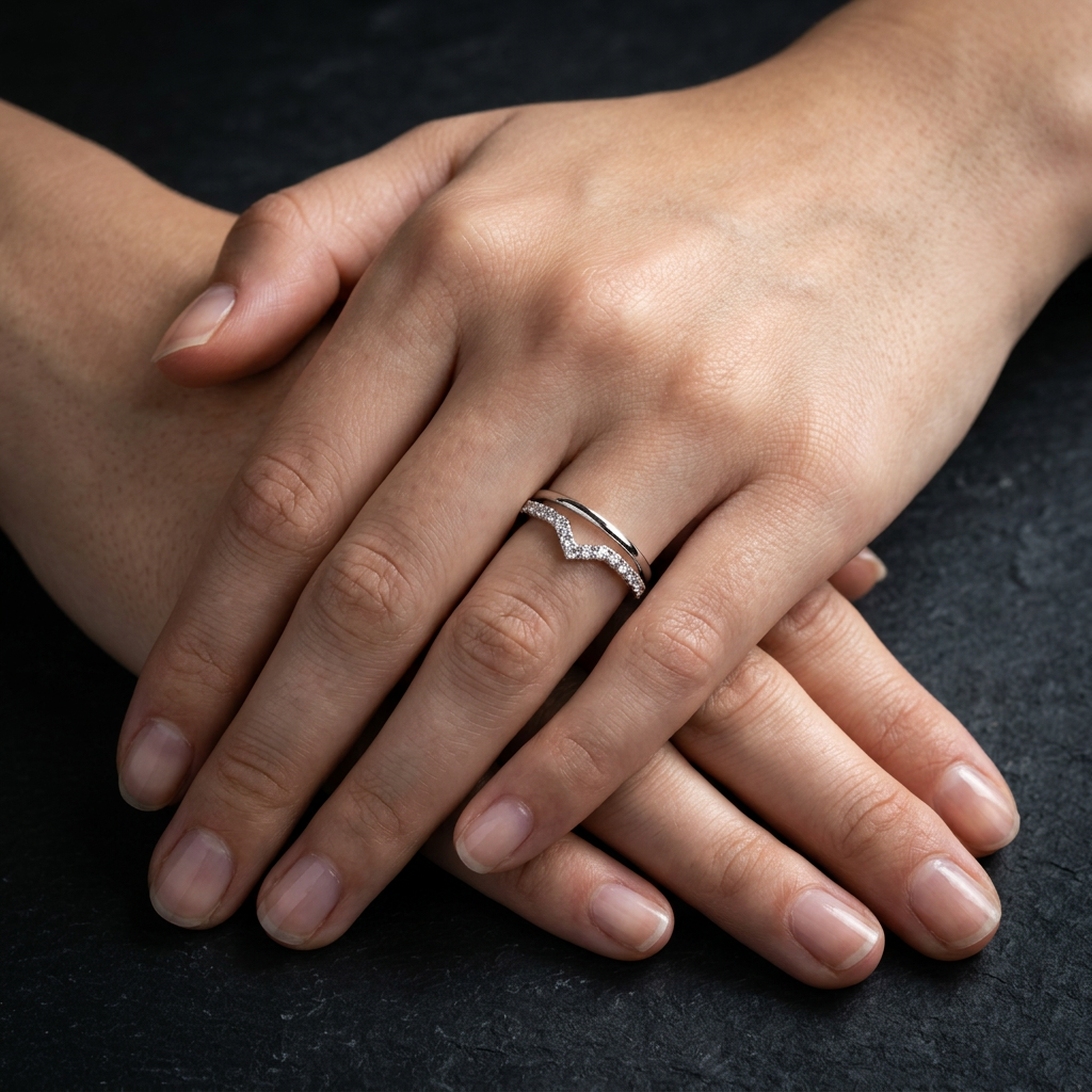 Macro photo focusing on the intricate micropavé stones set into a high-polish silver chevron V-shaped wedding band.