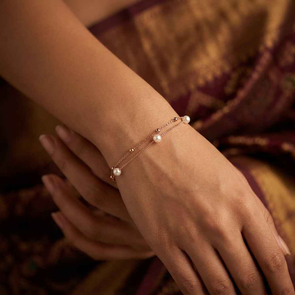 Delicate rose gold layered pearl chain worn by a female model, radiating a warm, sun-drenched glow.
