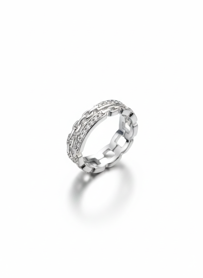 Macro photo focusing on the crisp high polish metal and detailed lines of brilliant pavé gems on an interlocking link ring.