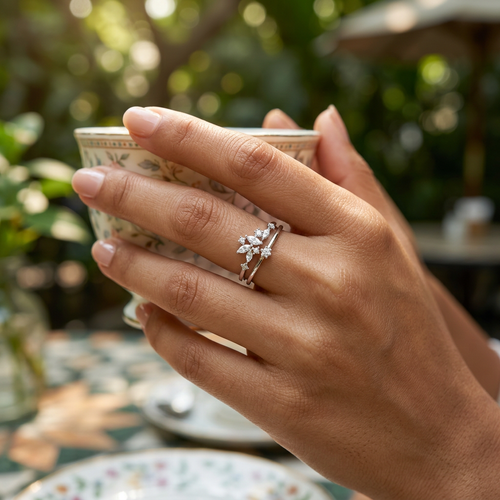 Close-up of a model wearing a sculptural silver celestial crown ring, showcasing its modern double band silhouette.