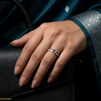 Close-up of a model wearing a tiered silver heart ring on her finger, displaying a sharp, contemporary look.