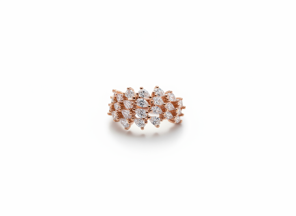 Studio flat lay of an organic rose gold botanical cluster ring resting cleanly on a smooth marble surface plate.