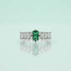 Real-world perspective showing a rectangular forest green emerald ring