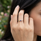 Macro photo focusing on the precision cut pear and marquise blue stones set on an organic rose gold band.