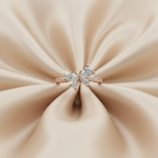 Micro shot showing the flawless setting of marquise and pear diamonds on a warm rose gold pavé butterfly ring.
