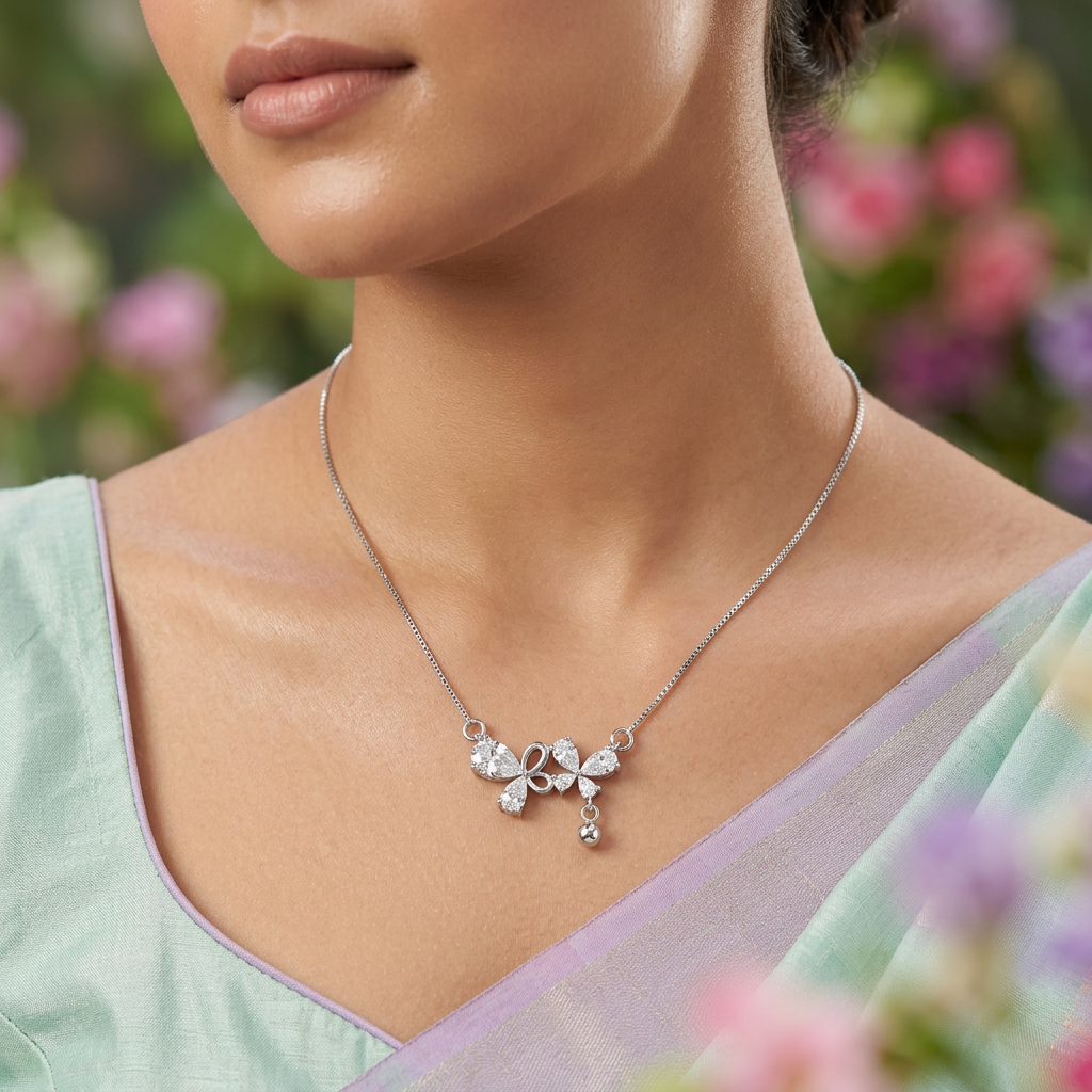 A delicate butterfly motif piece acting as a sophisticated, luminous anchor within a layered silver pear cut chain stack.