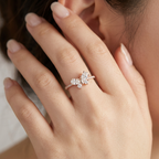 A model showcasing a rose gold butterfly ring set with shimmering marquise and pear diamonds on her finger.