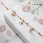 Extreme macro shot highlighting the intricate pavé stones on a rose gold crescent moon and star talisman.
