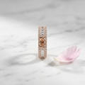 Front view of a wide rose gold heart ring framed by crisp baguette stones and fine pavé borders on a polished band.