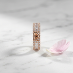 Front view of a wide rose gold heart ring framed by crisp baguette stones and fine pavé borders on a polished band.