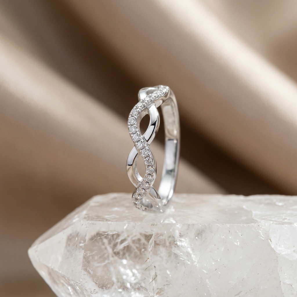 Front view of a silver diamond infinity ring showing interlaced bands set with brilliant delicate pavé stones.