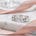 A stunning rose gold ring forming a butterfly silhouette with clean white enamel wings and diamond details.
