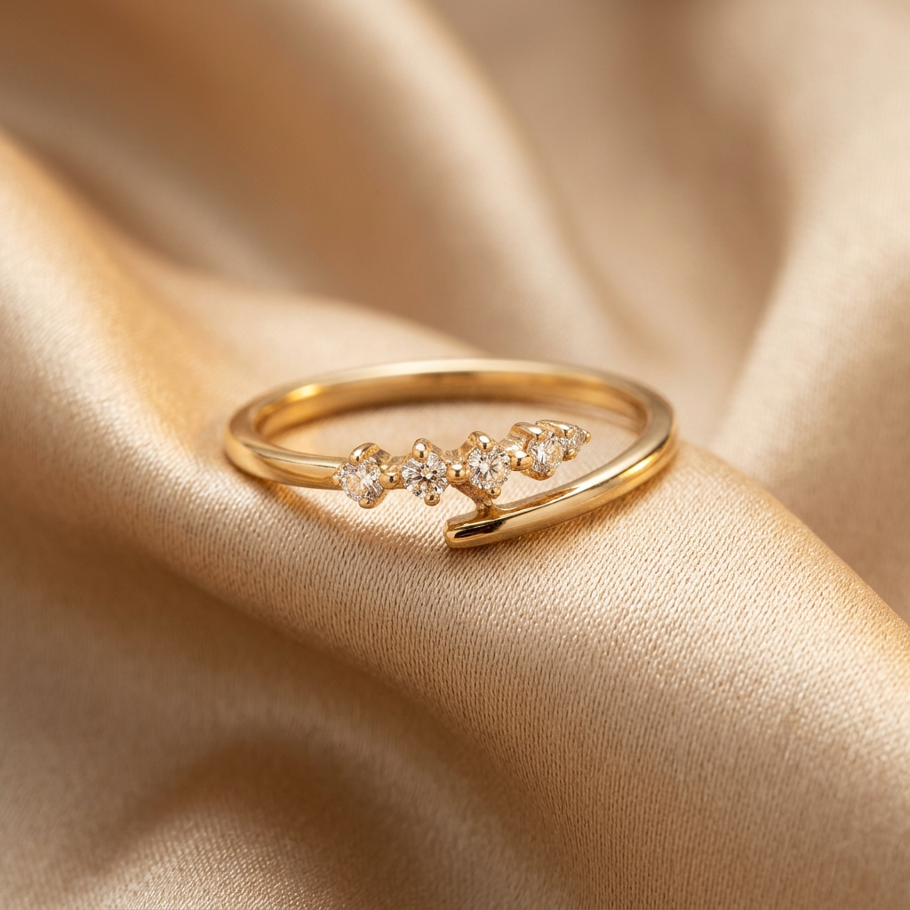 Close-up of a polished rose gold open band showcasing the graduation of four brilliant round-cut bezel diamonds.