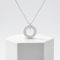 A polished white gold circle pendant featuring pavé-set faceted stones on a refined box chain for layered wear.