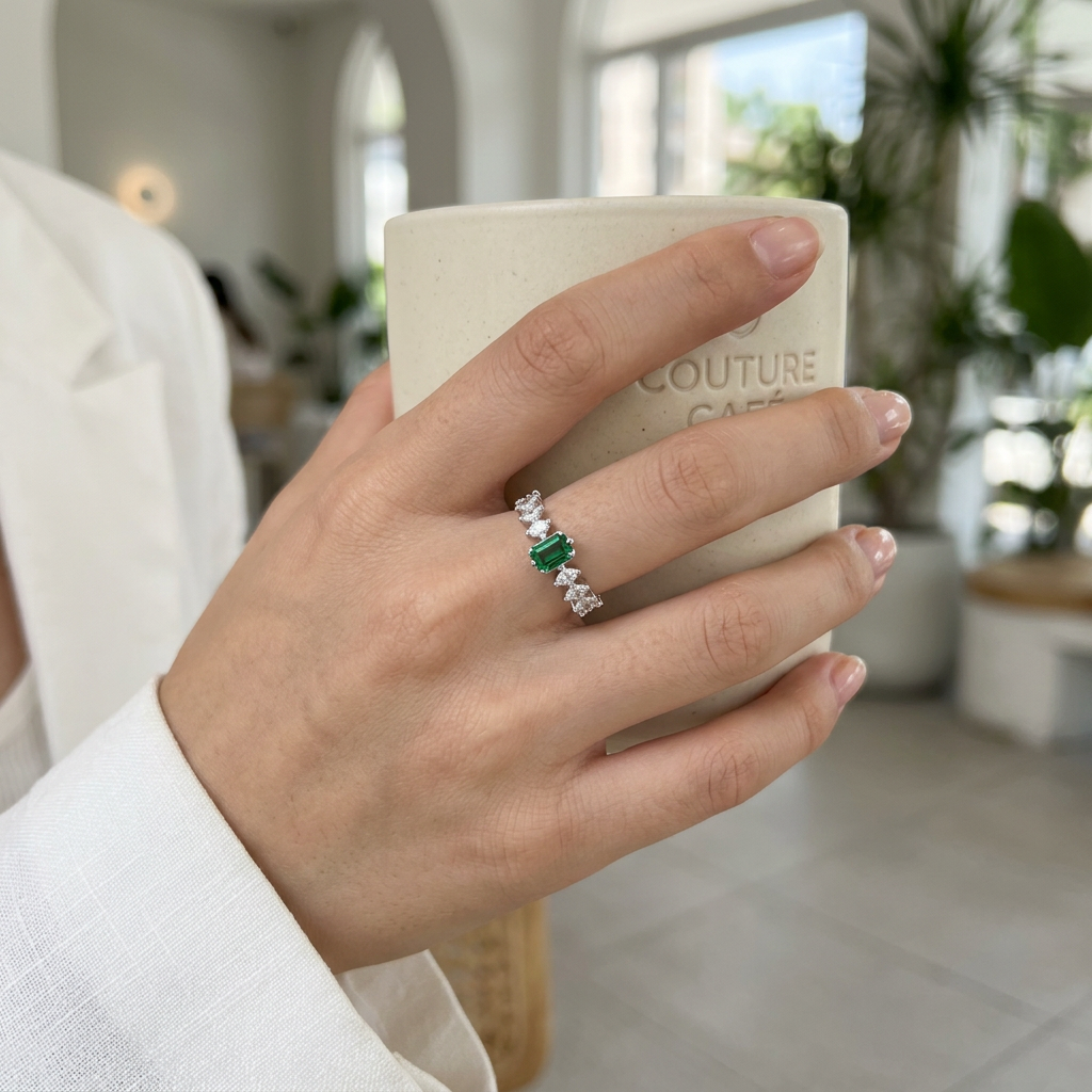 Top-down studio shot of a geometric forest green emerald ring isolated cleanly on a smooth background.