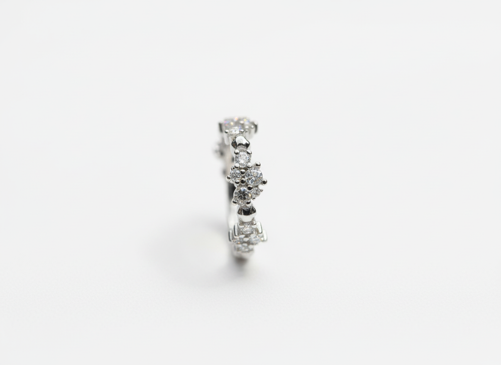 Top-down studio shot of a modern geometric sculptural crystal cluster ring isolated on a premium marble tile.