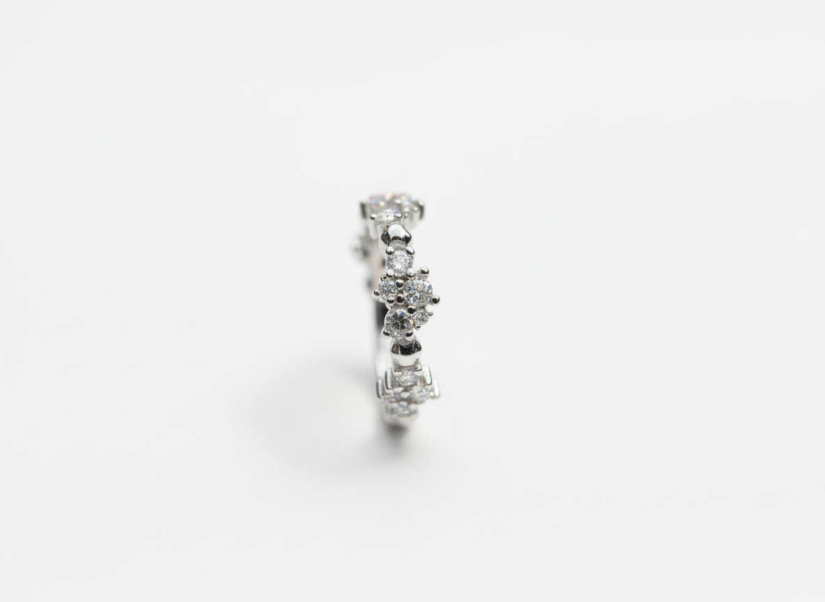 Top-down studio shot of a modern geometric sculptural crystal cluster ring isolated on a premium marble tile.