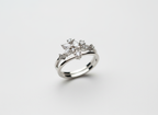 Top-down studio shot of a geometric silver celestial crown ring isolated cleanly on a smooth premium stone tile.
