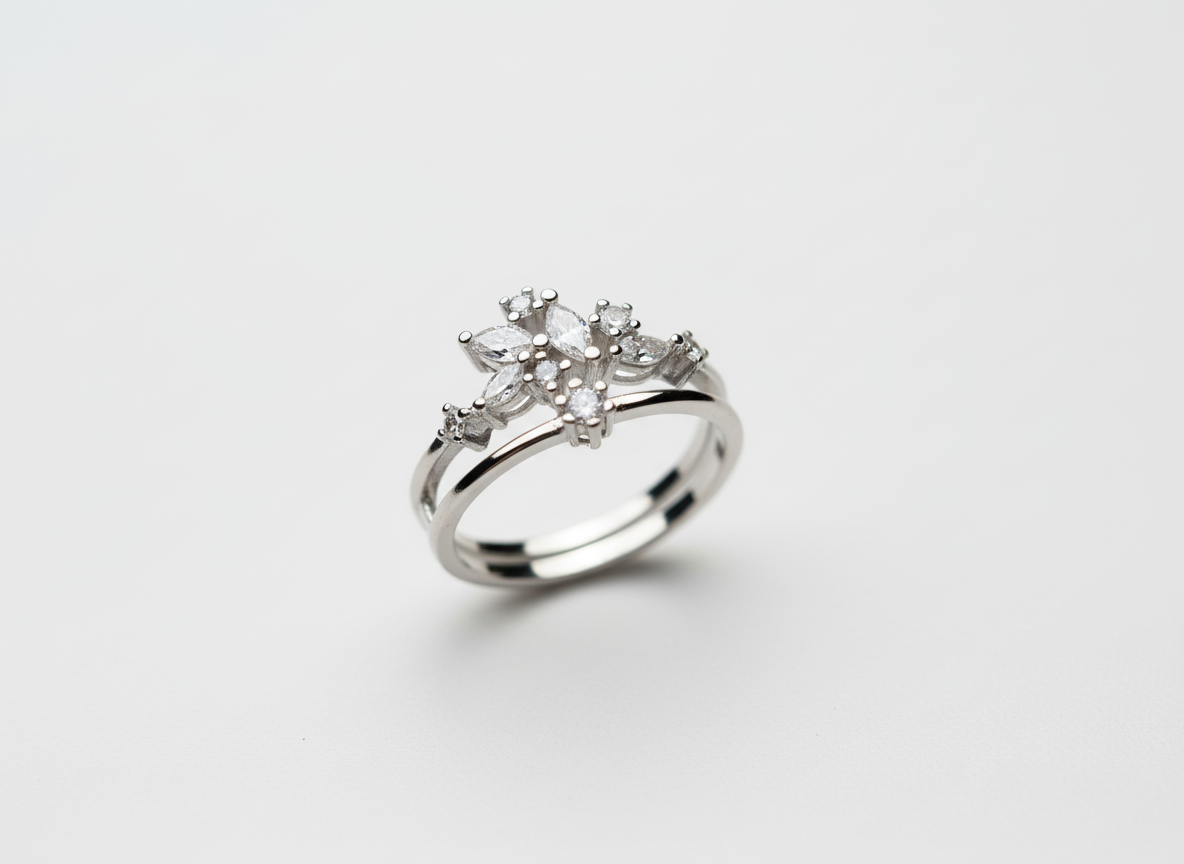 Top-down studio shot of a geometric silver celestial crown ring isolated cleanly on a smooth premium stone tile.