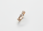 Top-down studio shot of an asymmetric rhythmic cluster ring isolated on a premium marble surface.