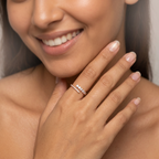 Luxury open-ended gold ring with bypass styling and graduated round diamonds worn as a contemporary stack alternative.