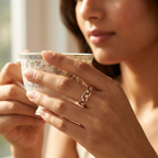 A fine rose gold open-frame ring with linear diamond rows styled on a woman's finger for a curated stack look.