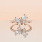 Studio product shot of a rose gold pavé band featuring a sculptural butterfly wing silhouette of cluster stones.