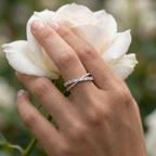 A polished silver crossover ring decorated with bright crystal gems