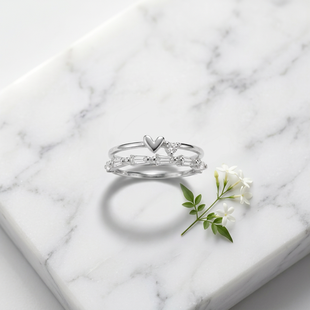 Front studio view of a polished silver heart ring featuring structured baguette cuts and a tiered multi-band silhouette.