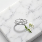 Front studio view of a polished silver heart ring featuring structured baguette cuts and a tiered multi-band silhouette.