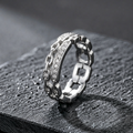 Front view of a cool toned silver interlocking link ring featuring sculptural bands and rows of clear pavé stones.
