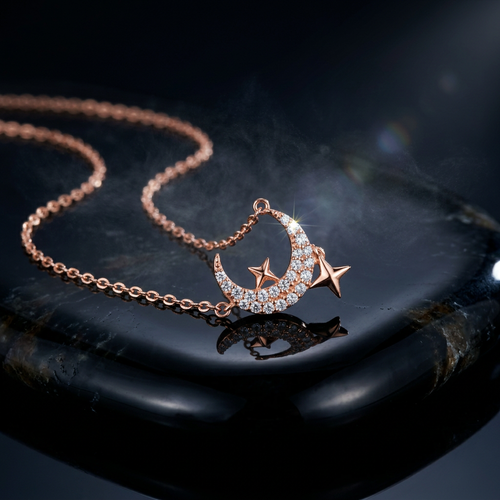 A delicate rose gold celestial necklace featuring a pavé-set crescent moon anchored by two sculptural stars.