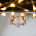 A rose gold rhythmic cluster ring showcasing a fluid pattern of marquise and round cut diamonds.