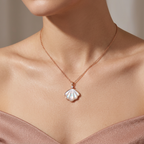 Close-up of a sculpted mother of pearl shell pendant featuring a brilliant diamond accent stone.