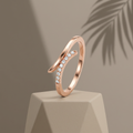A sculptural rose gold open ring featuring a fluid bypass silhouette accented with a delicate path of pavé stones.