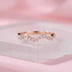 An undulating rose gold wave ring featuring a fluid organic silhouette traced with delicate pavé-set diamonds.