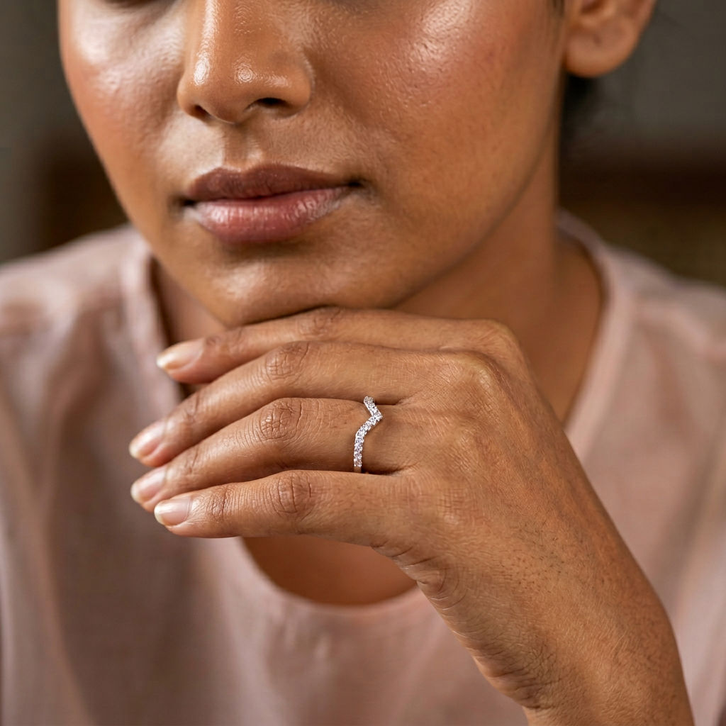 Editorial view of a model wearing a polished sterling silver wishbone ring with a sharp, modern architectural finish.
