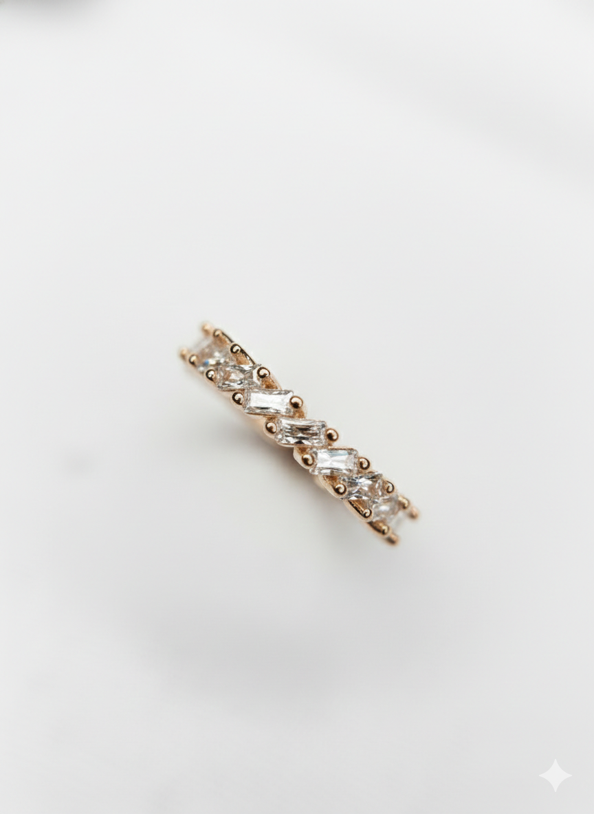 An elegant fine jewelry rose gold baguette ring with sharp geometric textures, styled as a premium holiday gift.