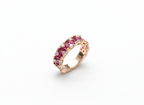 A premium rose gold eternity band set with deep red rubies, presented as a luxury milestone anniversary gift.