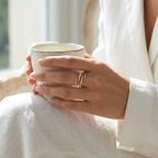 A close-up lifestyle view of a woman holding a cup, beautifully showcasing a sharp thorn design ring intricately set with brilliant pavé lab grown diamonds.